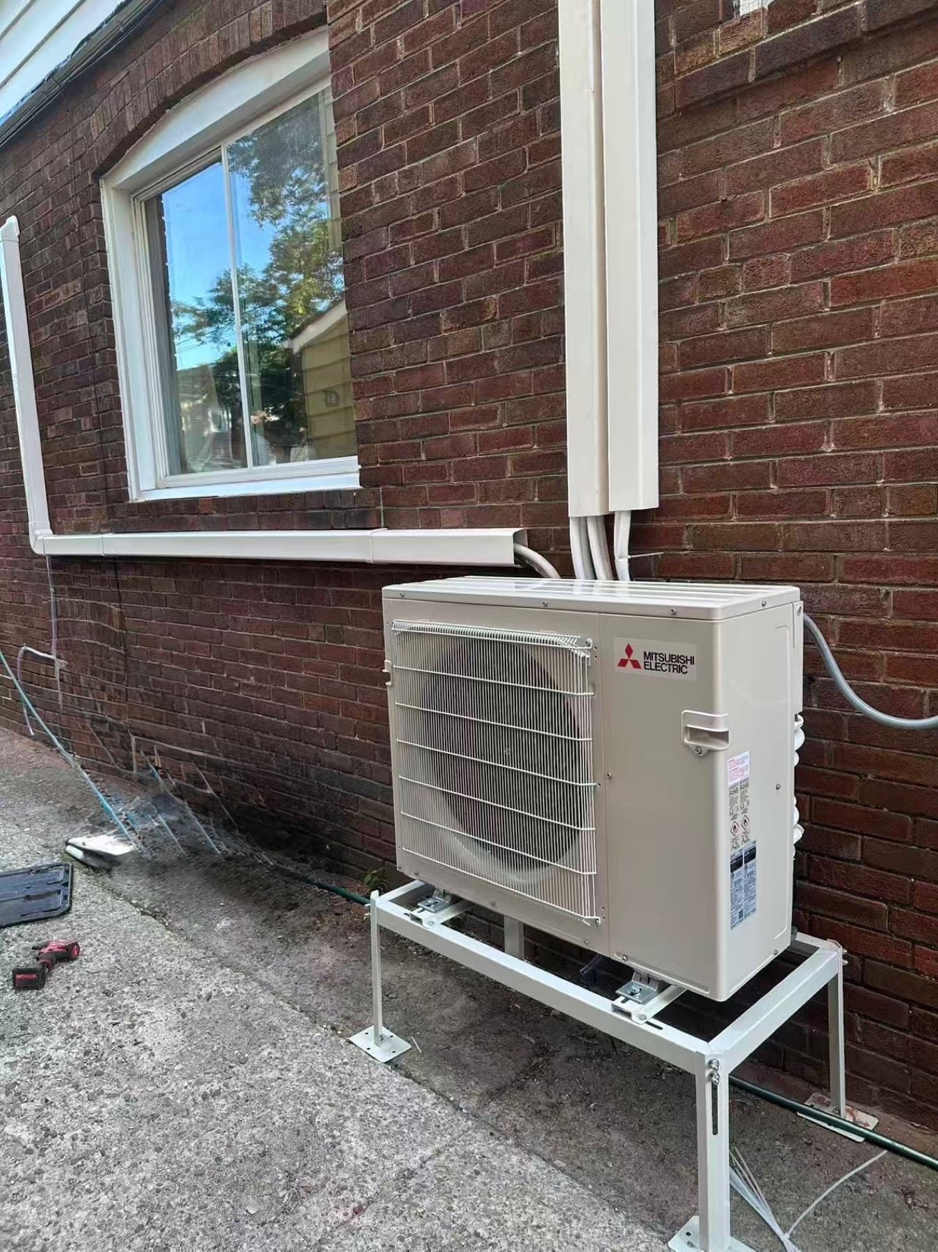 Mitsubishi ductless outdoor unit on a custom stand